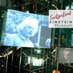 Image of mirrored hall at Einstein Museum in Bern Switzerland with a variety of pictures of Albert Einstein with text overlay, "Switzerland: Einstein Museum". Visit Bern with Kids.