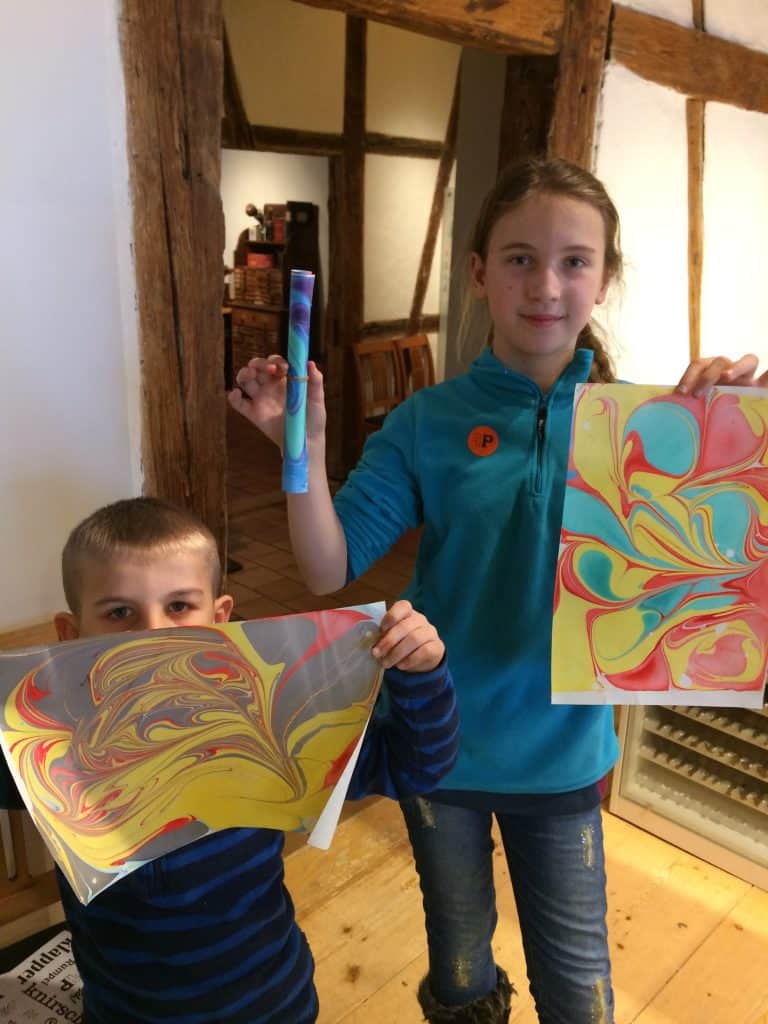 Image of 2 kids at holding Marbled paper art from a Basel Museum