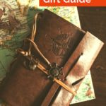 Image of travel journal and map with text overlay A Traveler's Gift Guide
