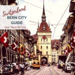 Image of Old Town in Bern, Switzerland. Clock Tower and streets lined with Swiss flags with Text overlay saying "Bern Switzerland City Guide : A Must Do List."