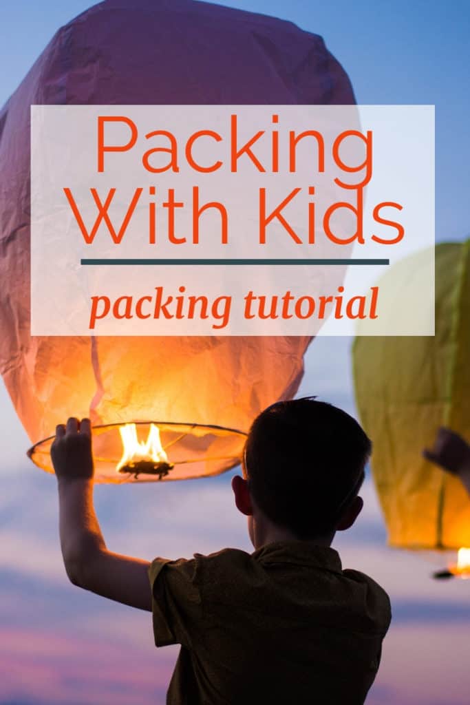 image of child with releasing paper lantern at sunset with text overlay Packing with Kids: Packing Tutorial.