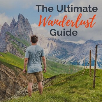Image of man in blue shirt in the Swiss Alps admiring enormous mountains In the background with text overlay, The Ultimate Wanderlust Guide.