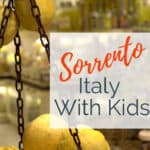 Image of lemons in basket with Italian ceramics in background with text overlay Sorrento with Kids