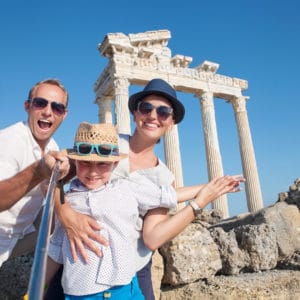 image of family taking selfie in front of greek temple. Homeschool Travel Learn at www.captivatingcompass.com