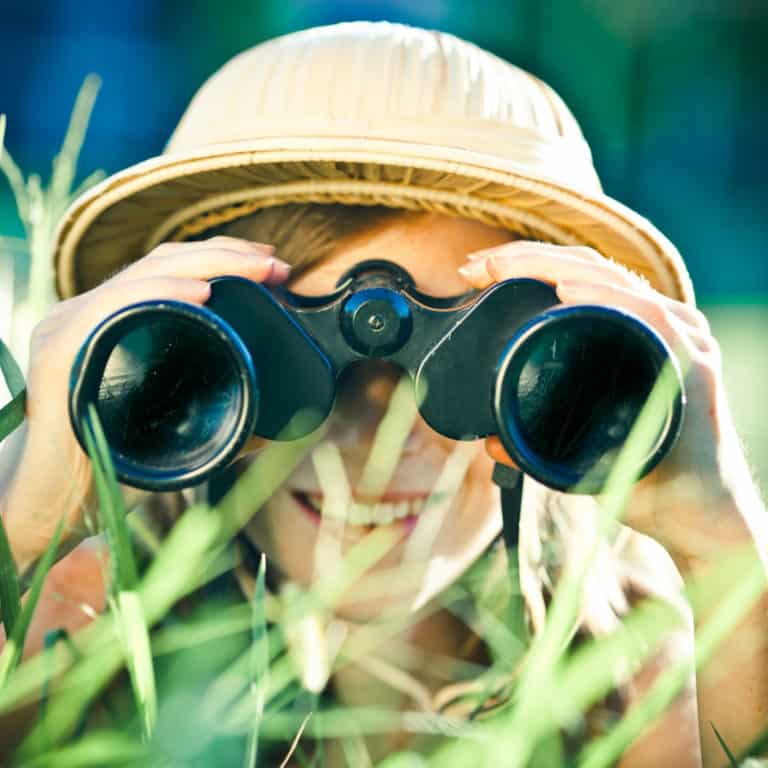 image of girl looking through binoculars. Homeschool Travel Learn at www.captivatingcompass.com